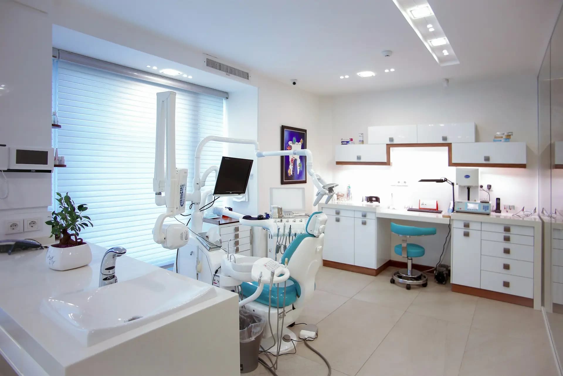 A bright, modern treatment room with a dental chair by the window