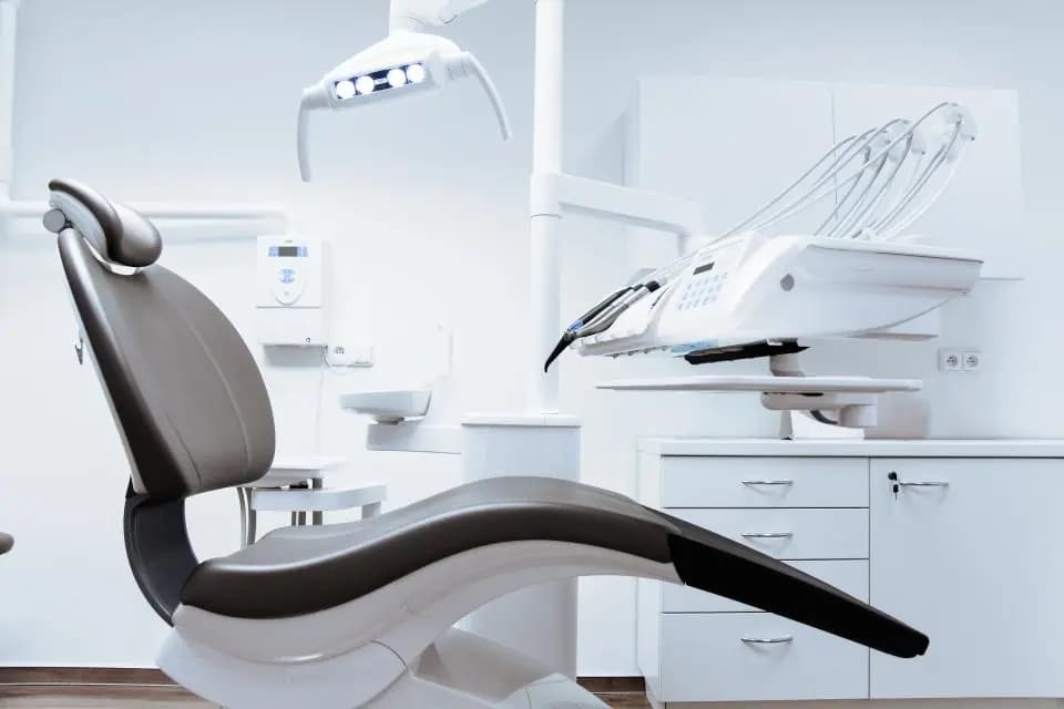 A white dental chair in a calm, light treatment room